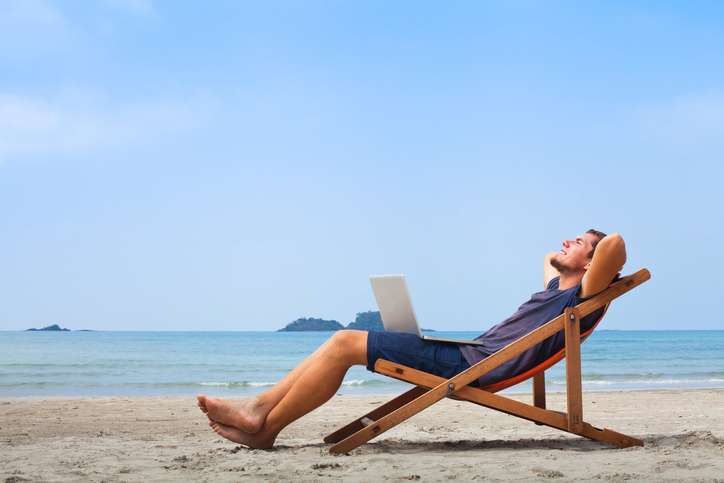 freelancer, happy successful businessman with laptop on the beach, blue sky